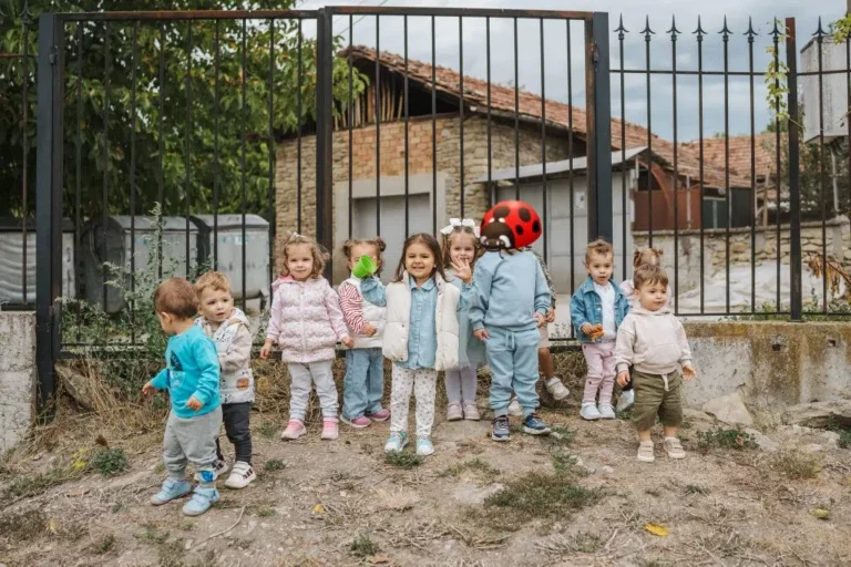 Група деца навън край оградата на двора в Монтесори къща "Под крилото" град Велико Търново Леденик